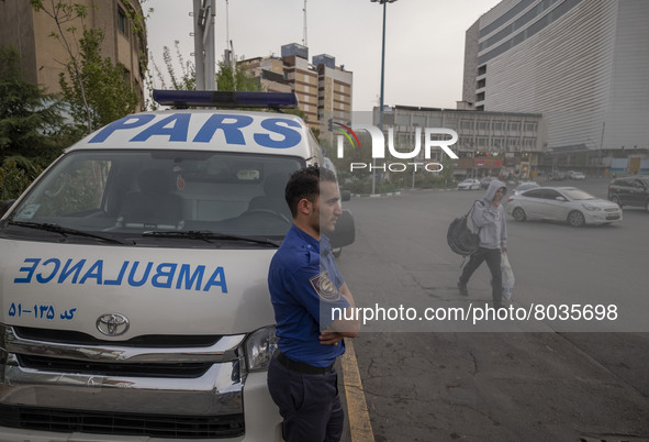 A health personnel stands next to an ambulance on a corner of a square in Tehran during a polluted air, on April 8, 2022. 