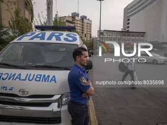 A health personnel stands next to an ambulance on a corner of a square in Tehran during a polluted air, on April 8, 2022. (