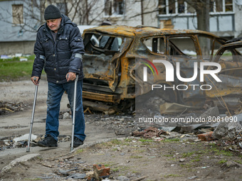 A man takes a walk with his crutches near his house after being wounded in a russian shelling over Chernihiv, Ukraine. (