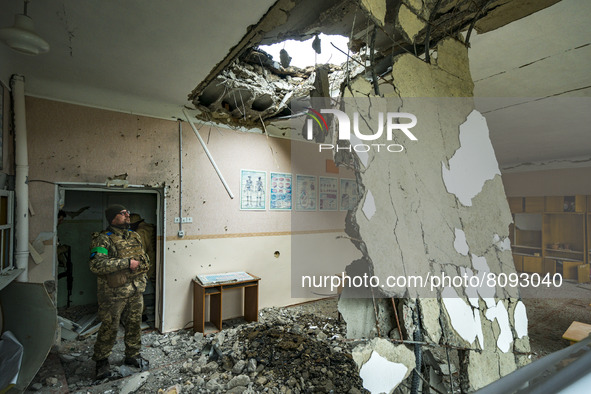 A ukrainian soldier looks the aftermath of a russian shelling over a school in Luch, a village near the frontline in Mykolaiv region, Ukrain...