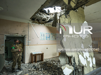 A ukrainian soldier looks the aftermath of a russian shelling over a school in Luch, a village near the frontline in Mykolaiv region, Ukrain...
