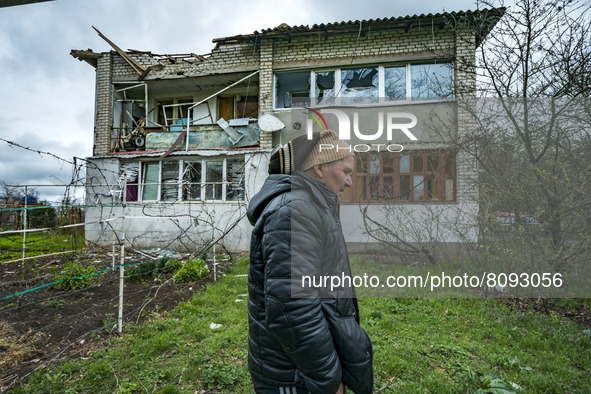 A man walks under his house destroyed by russian shelling over the village of Luch, near the frontline between the russian and ukrainian arm...