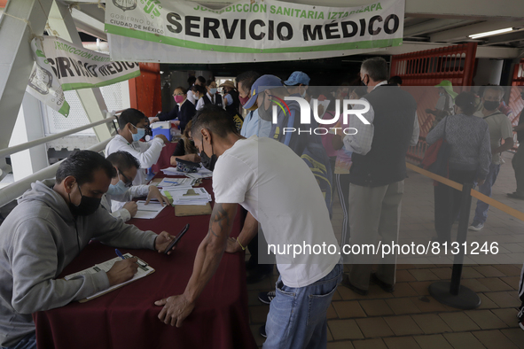 Medical personnel offer reports to people in a vaccination unit at the Constitución de 1917 metro station in Mexico City, where the AstraZen...