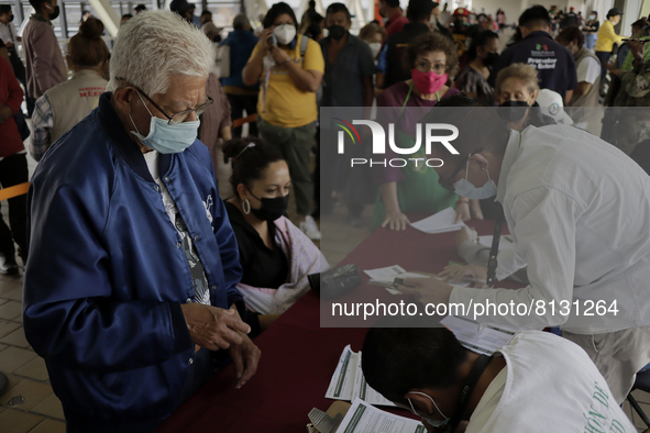 Medical personnel offer reports to people in a vaccination unit at the Constitución de 1917 metro station in Mexico City, where the AstraZen...