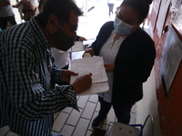 A Person fill out a form preview to receive a  Covid-19 booster dose during a vaccination program in the local markets as attempt to reduce...