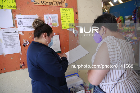 A Person fill out a form preview to receive a  Covid-19 booster dose during a vaccination program in the local markets as attempt to reduce...