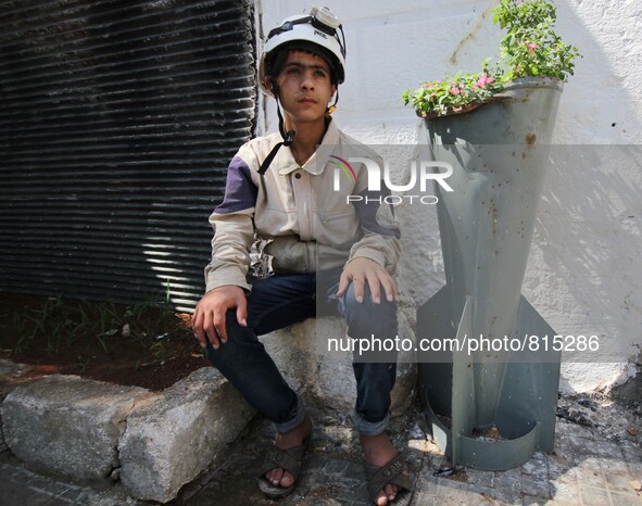 Malik Sabag a 15-year-old Syrian civil defense member, Malik is sitting next to unexploded bomb which is planted with flowers and this bomb...