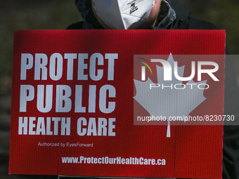 A protester holds a placard with words 'Protect Public Health Care'.
Health-care workers, activists and their supporters protested this afte...