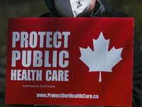 A protester holds a placard with words 'Protect Public Health Care'.
Health-care workers, activists and their supporters protested this afte...