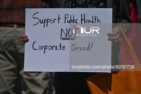 A protester holds a placard with words 'Support Public Health Care NIOT Corporate Greed!'.
Health-care workers, activists and their supporte...