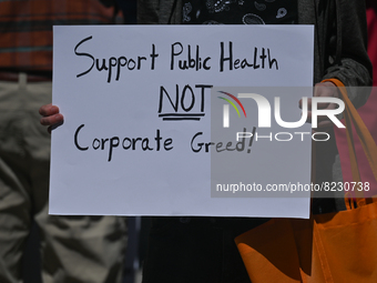 A protester holds a placard with words 'Support Public Health Care NIOT Corporate Greed!'.
Health-care workers, activists and their supporte...