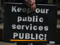 A protester holds a placard with words 'Keep our public services PUBLIC!'.
Health-care workers, activists and their supporters protested thi...