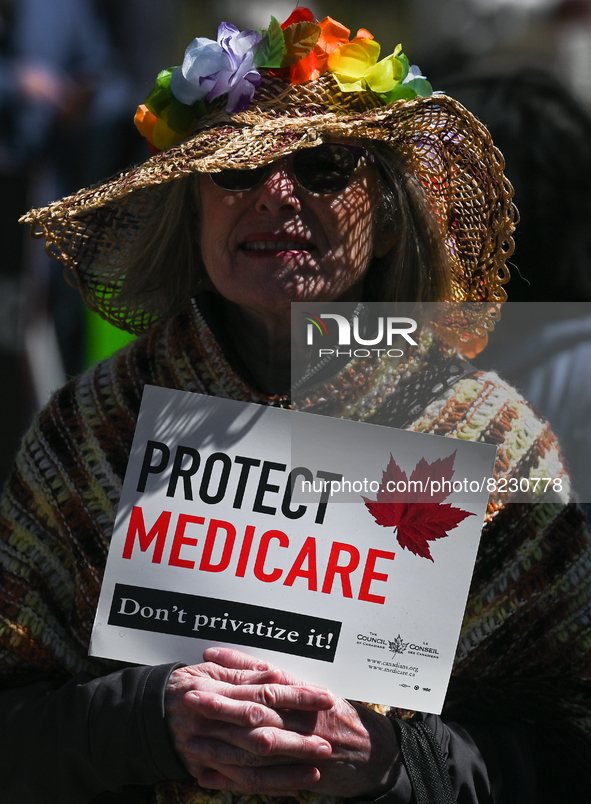 A protester holds a placard with words 'Protect Medicare. Don't Privatize It!'.
Health-care workers, activists and their supporters proteste...