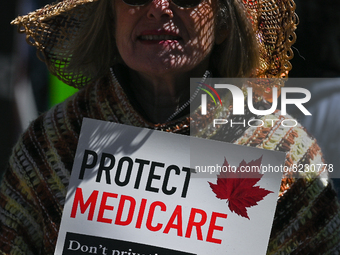 A protester holds a placard with words 'Protect Medicare. Don't Privatize It!'.
Health-care workers, activists and their supporters proteste...