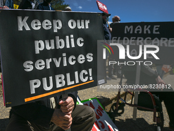 Protesters hold placards with words Keep our public Services Public!' and 'Make Eldercare Safe!.
Health-care workers, activists and their su...