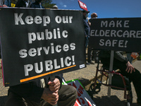 Protesters hold placards with words Keep our public Services Public!' and 'Make Eldercare Safe!.
Health-care workers, activists and their su...