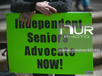 A protester holds a placard with words 'Independent Seniors' Advocate NOW!'.
Health-care workers, activists and their supporters protested t...