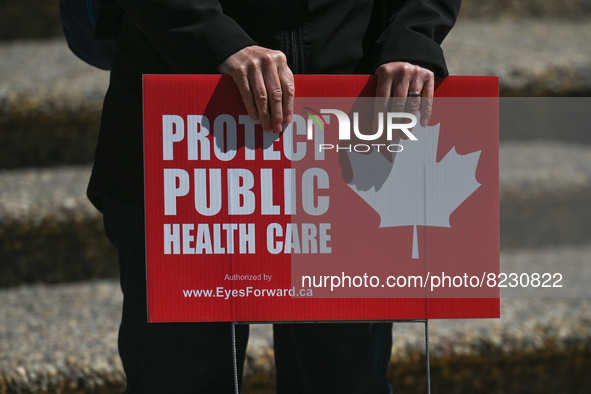 A protester holds a placard with words 'Protect Public Health Care'.
Health-care workers, activists and their supporters protested this afte...