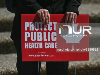 A protester holds a placard with words 'Protect Public Health Care'.
Health-care workers, activists and their supporters protested this afte...