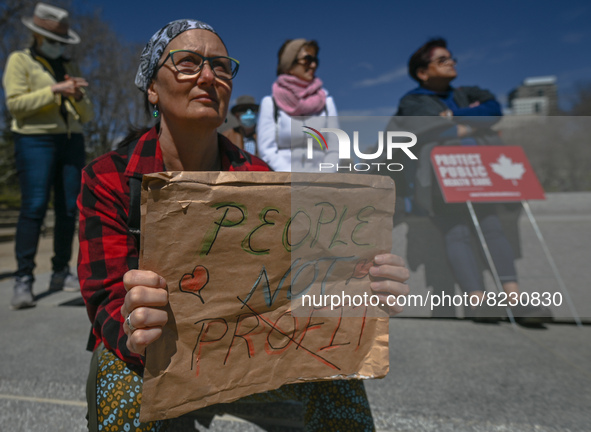 A protester holds a placard with words 'People Not Profit'.
Health-care workers, activists and their supporters protested this afternoon dur...