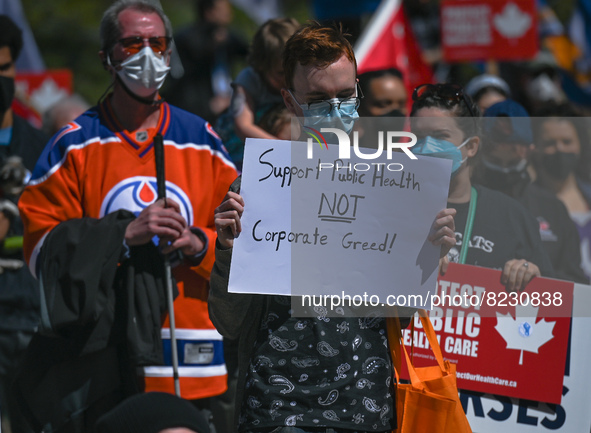 A protester holds a placard with words 'Support Public Health NOT Corporate Greed!'.
Health-care workers, activists and their supporters pro...