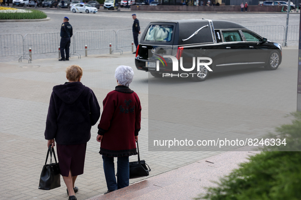 Two woman look at the catafalque with the coffin of the first president of Ukraine Leonid Kravchuk in Kyiv, Ukraine, May 17, 2022. Dozens of...