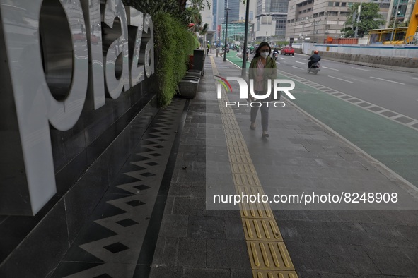 People wearing a protective mask walk in Jakarta, Indonesia, on May 18, 2022 amid the COVID-19 pandemic. 