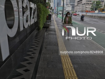 People wearing a protective mask walk in Jakarta, Indonesia, on May 18, 2022 amid the COVID-19 pandemic. (