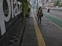 People wearing a protective mask walk in Jakarta, Indonesia, on May 18, 2022 amid the COVID-19 pandemic. (