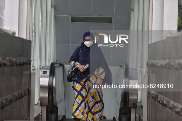 People wearing a protective mask walk in Jakarta, Indonesia, on May 18, 2022 amid the COVID-19 pandemic. 