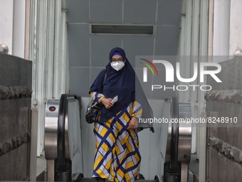 People wearing a protective mask walk in Jakarta, Indonesia, on May 18, 2022 amid the COVID-19 pandemic. (