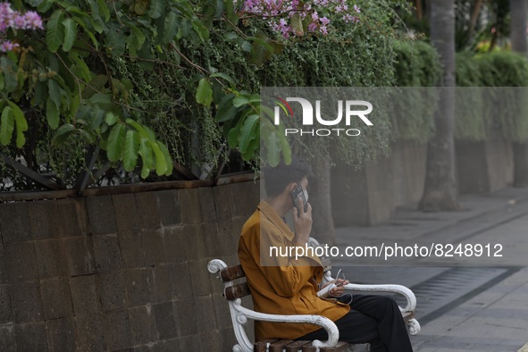 People wearing a protective mask walk in Jakarta, Indonesia, on May 18, 2022 amid the COVID-19 pandemic. 