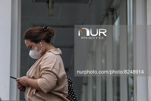 People wearing a protective mask walk in Jakarta, Indonesia, on May 18, 2022 amid the COVID-19 pandemic. 