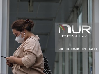 People wearing a protective mask walk in Jakarta, Indonesia, on May 18, 2022 amid the COVID-19 pandemic. (