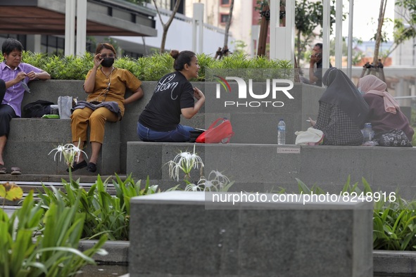 People wearing a protective mask walk in Jakarta, Indonesia, on May 18, 2022 amid the COVID-19 pandemic. 