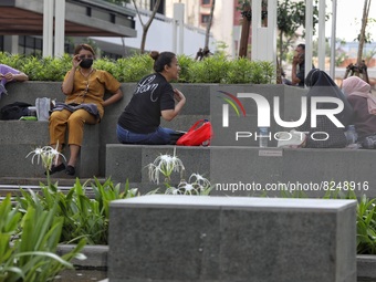 People wearing a protective mask walk in Jakarta, Indonesia, on May 18, 2022 amid the COVID-19 pandemic. (