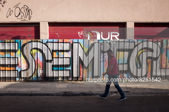 A man is passing in front of a graffiti in Athens, Greece on May 18, 2022. A committee of experts from the Health Ministry are examining the...