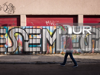 A man is passing in front of a graffiti in Athens, Greece on May 18, 2022. A committee of experts from the Health Ministry are examining the...