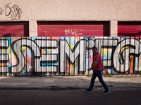 A man is passing in front of a graffiti in Athens, Greece on May 18, 2022. A committee of experts from the Health Ministry are examining the...