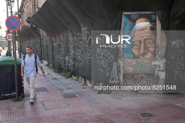 A man is passing in front of a graffiti in Athens, Greece on May 18, 2022. A committee of experts from the Health Ministry are examining the...