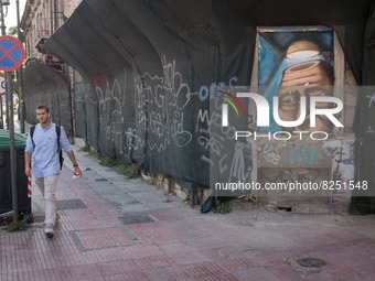 A man is passing in front of a graffiti in Athens, Greece on May 18, 2022. A committee of experts from the Health Ministry are examining the...