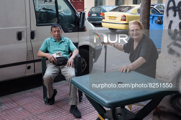 A elderly woman and a man are sitted outside a store in Athens, Greece on May 18, 2022. A committee of experts from the Health Ministry are...