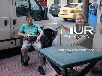 A elderly woman and a man are sitted outside a store in Athens, Greece on May 18, 2022. A committee of experts from the Health Ministry are...