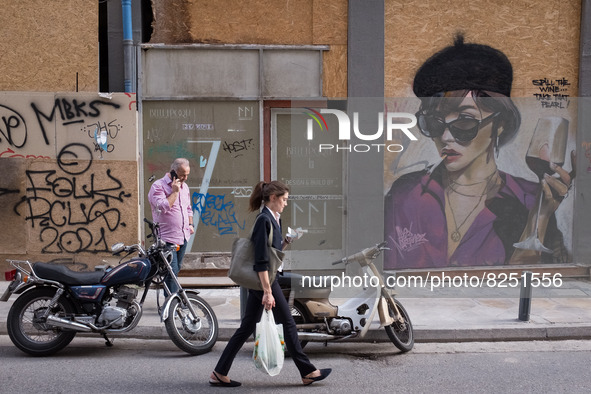 People are passing in front of a graffiti in Athens, Greece on May 18, 2022. A committee of experts from the Health Ministry are examining t...