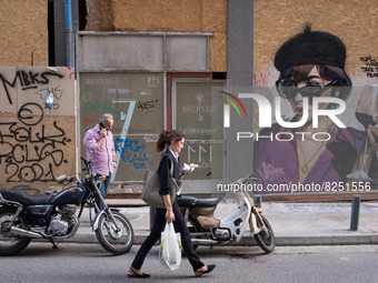 People are passing in front of a graffiti in Athens, Greece on May 18, 2022. A committee of experts from the Health Ministry are examining t...