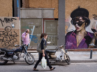 People are passing in front of a graffiti in Athens, Greece on May 18, 2022. A committee of experts from the Health Ministry are examining t...