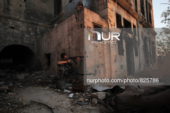 A fighter from the Free Syrian Army takes position following clashes with the pro-regime forces, in the old quarter of the northern Syrian c...