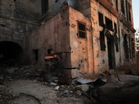 A fighter from the Free Syrian Army takes position following clashes with the pro-regime forces, in the old quarter of the northern Syrian c...