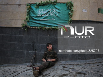 A fighter from the Free Syrian Army gets rest following clashes with the pro-regime forces, in the old quarter of the northern Syrian city o...
