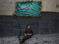 A fighter from the Free Syrian Army gets rest following clashes with the pro-regime forces, in the old quarter of the northern Syrian city o...